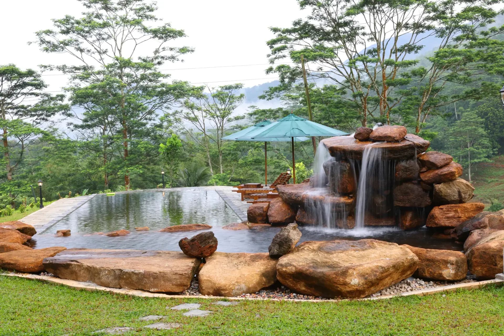 Spring-fed natural pool with rock waterfall and mountain views