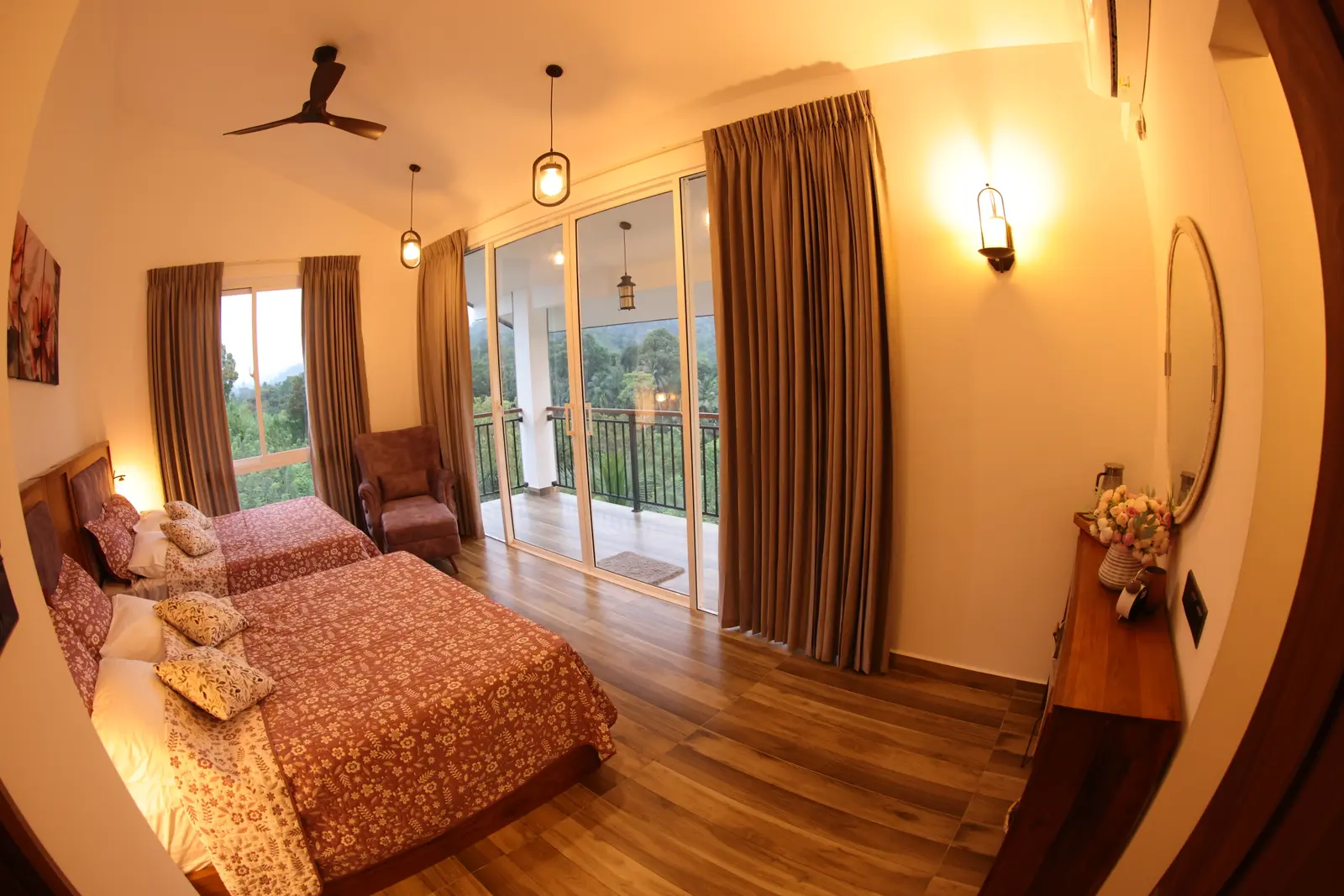 Twin beds with terracotta floral bedding, armchair, and forest views through the balcony