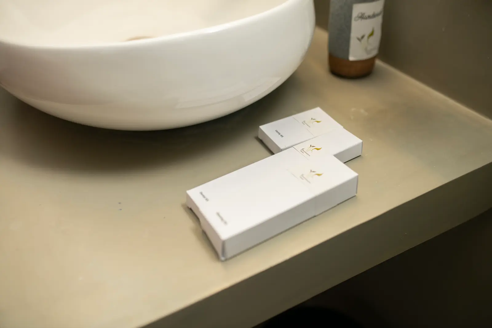 Dental kit and vanity kit on the ensuite counter beside a vessel sink