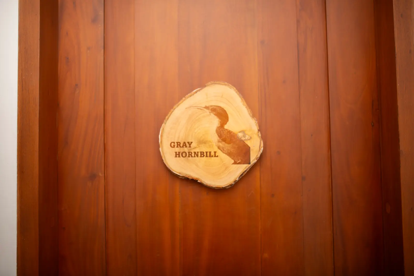 Wood-slice door sign engraved with a Gray Hornbill