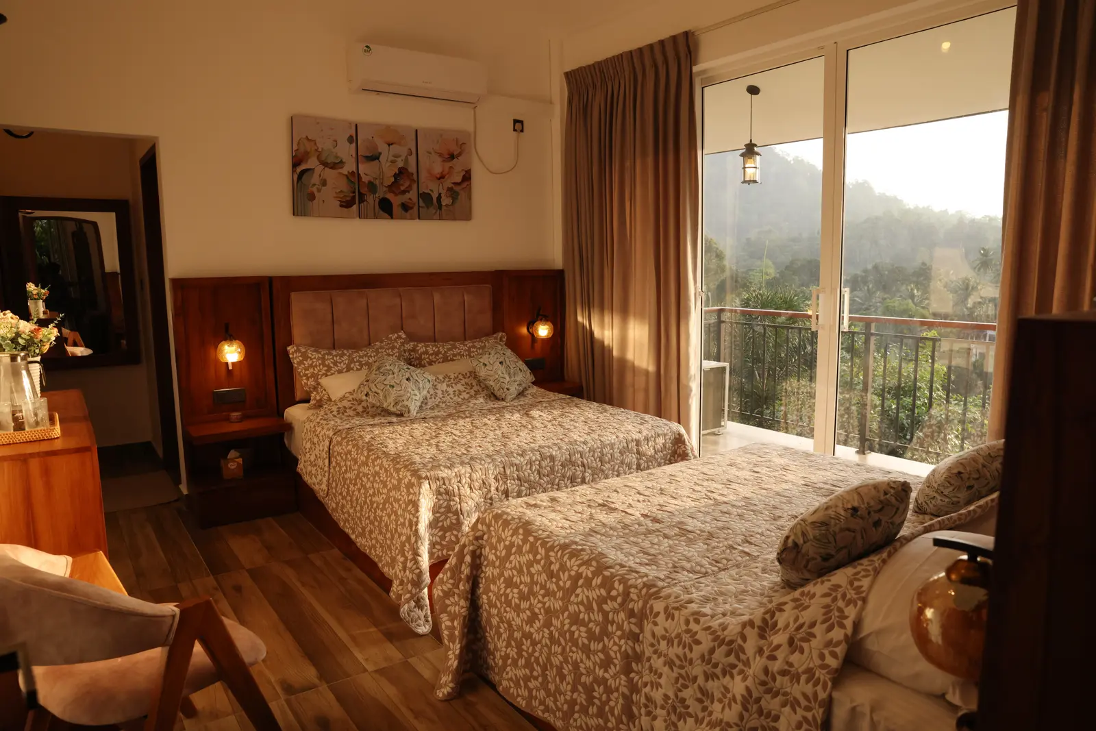 Twin beds with leaf-pattern bedding, balcony, and forest views