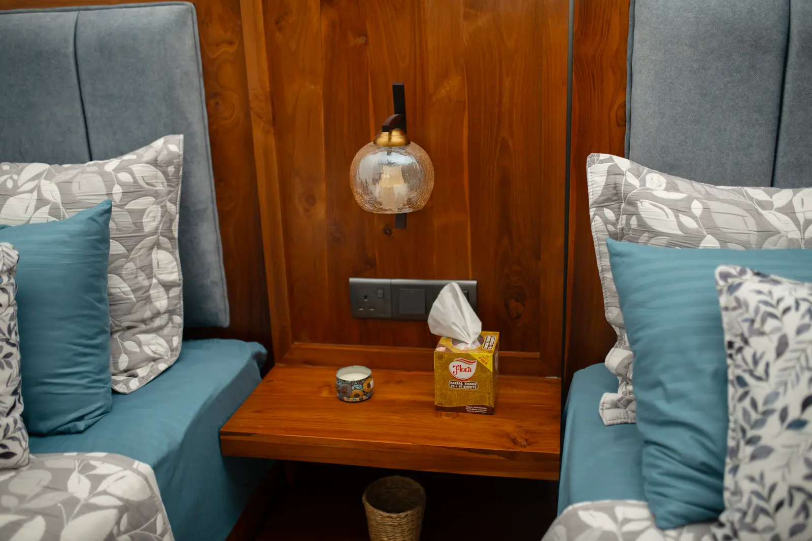 Floating nightstand between twin beds with amber reading lamps