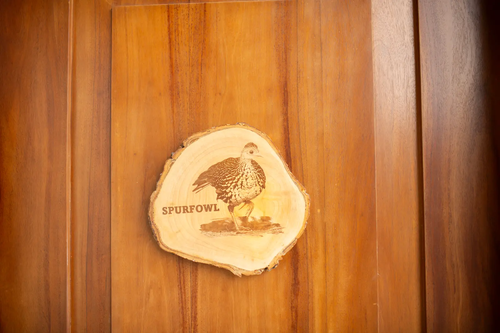 Wood-slice door sign engraved with a Spurfowl